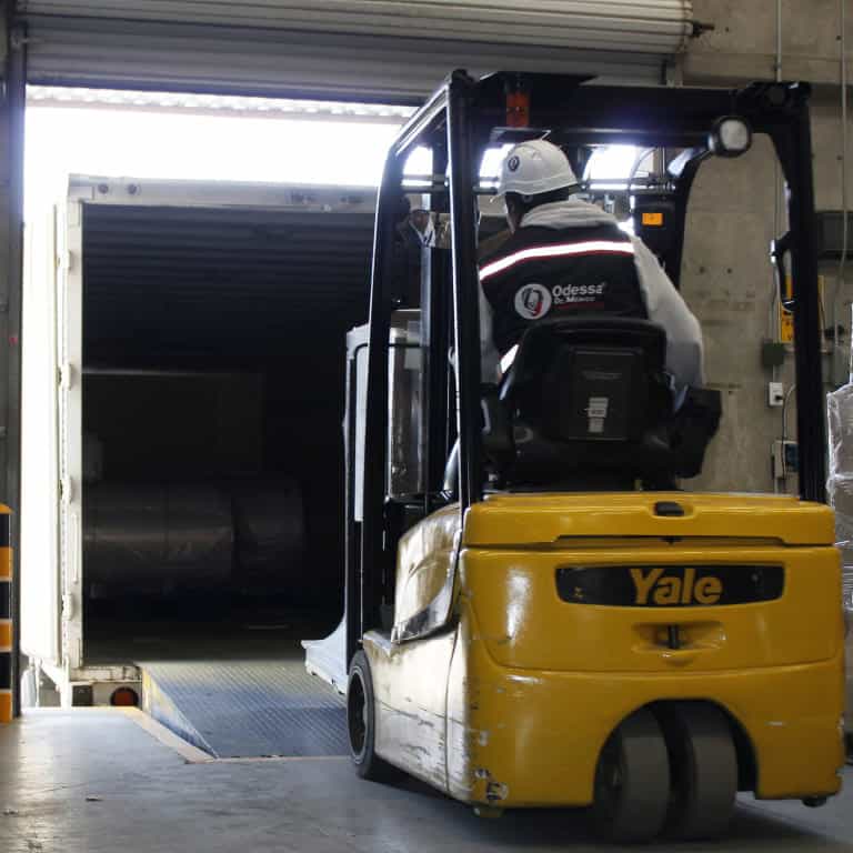 Operario manejando montacargas en centro de distribución.