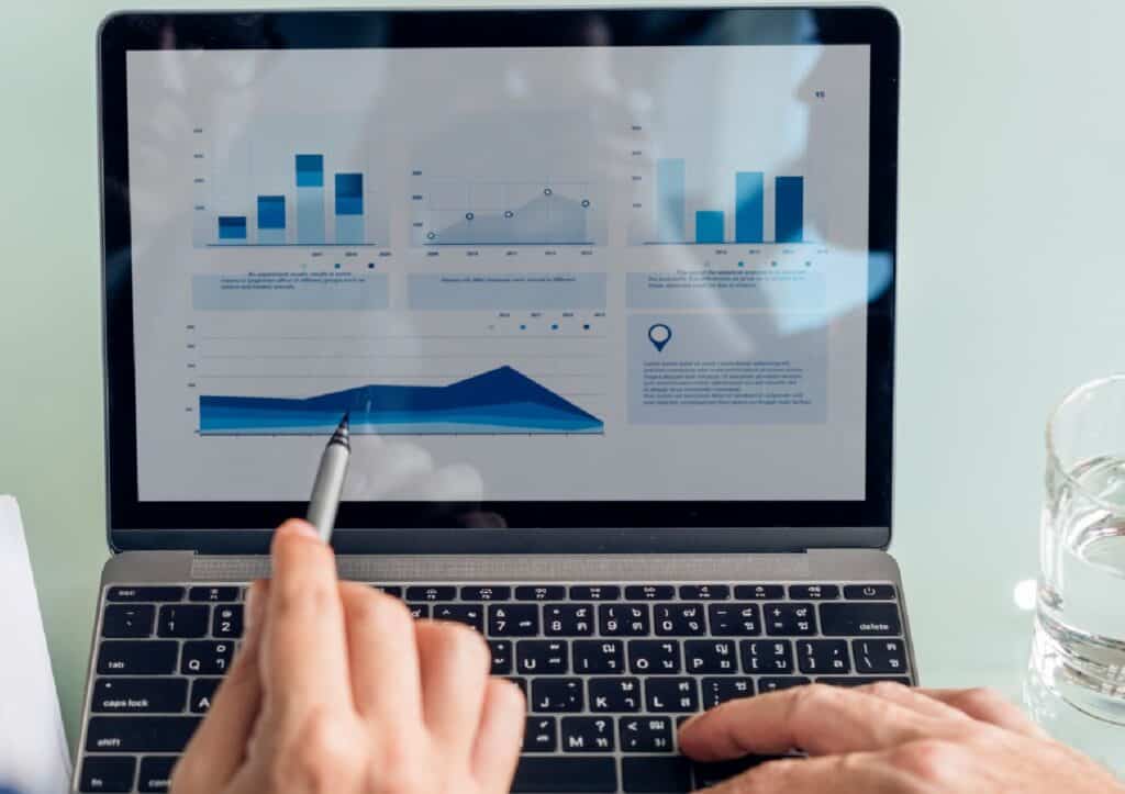 Persona analizando gráficos de logística en laptop para KPIs logísticos.